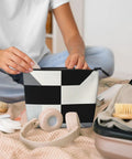 Level Up Your Packing Game With This Legit Black And White Piano Grid Print Large Toiletry Bag crafted from water repellent polyester fabric, held by a person.