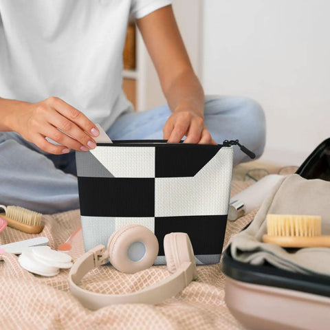 Level Up Your Packing Game With This Legit Black And White Piano Grid Print Large Toiletry Bag crafted from water repellent polyester fabric, held by a person.