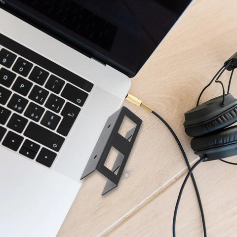 Heavy Duty Laptop Stand And Tablet Mount Under Desk Organizer Rack Black next to a laptop and headphones on a wooden desk.