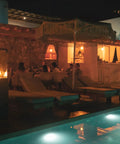 Smokeless 360 Degree Propane Patio Heater, 41,000 BTU, 59 Inch Freestanding Glass Tower On Wheels at night by poolside