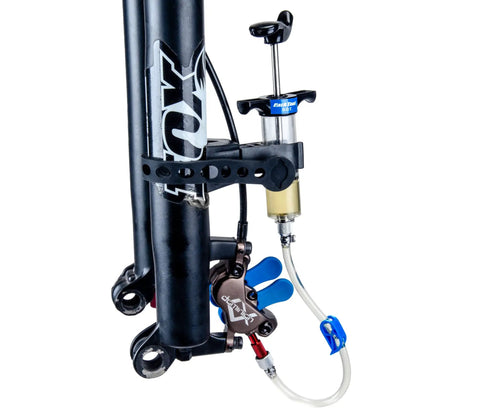 Heavy Duty Hydraulic Bicycle Brake Bleed Kit With DOT Fluid Dual Syringes Quick Connect Hoses attached to bike fork