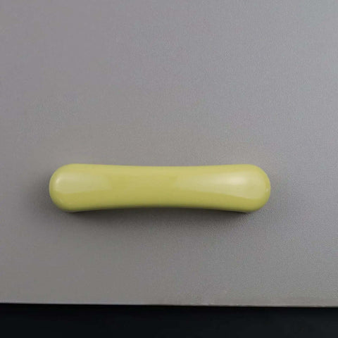 Four Piece Set Of Glossy Yellow Ceramic Cabinet Pulls Featuring A Slick High Gloss Finish And Heavy Duty Craftsmanship Ideal For Kitchen Cabinets And Zero Sweat Home Renos - close-up view of a single glossy yellow ceramic pull.