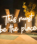Warm white LED neon sign This Must Be The Place on display, 21.65 x 12.4 inches, for bedroom bar office cafe party decor.