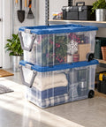 Premium Heavy Duty Wheeled Storage Bins 160 Quart 2 Pack Rolling Carts With Sturdy Metal Axle And Swivel Pull Handle stacked with holiday decor and blankets.