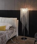 Crystal Floor Lamp With Rainfall Sparkle beside a bed in a bedroom, silver chrome finish, elegant lava style for romantic vibes.