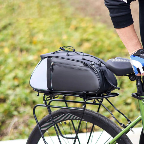 Cyclist with Rear Rack Bike Bag 12L Water-Resistant Trunk Pannier With Reflectors For Bikepacking And Commuting, mounted on green bike.