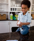 Child holding Granite Cleaner And Polish For Marble Quartz Slate And Concrete Surfaces Streak Free Stone Countertop Cleaner