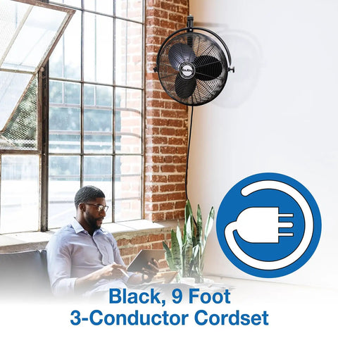 Industrial Grade Wall Mount Fan 20 Inch Black One Sixth Horsepower Three Speed 120 Volt next to man working by window