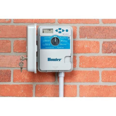 Mounted XC 600 Hybrid Battery Powered Irrigation Controller With Six Zone Sprinkler Timers on red brick wall