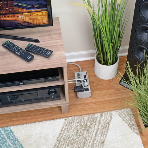 Heavy Duty 6 Outlet Power Strip Surge Protector With 3330 Joules 6 Foot Cord in living room setup on floor by TV stand