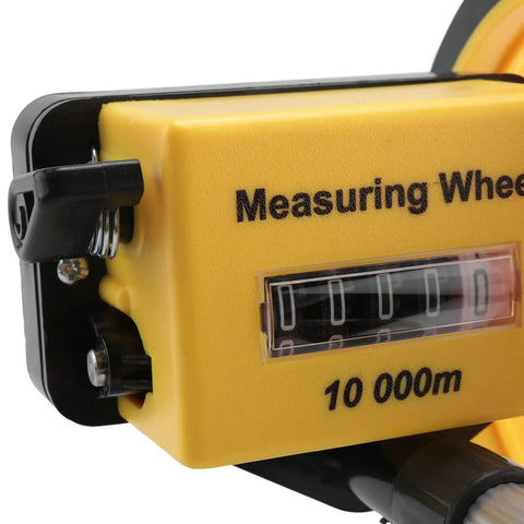 Close-up of measuring wheel with foldable telescopic handle, 0-9999.9m range, showing yellow casing and distance tracker.