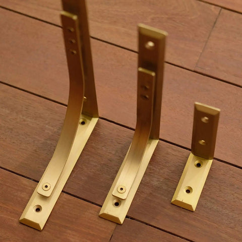 Heavy Duty Shelf Brackets Wall Mount Kickass Brass Metal Supports showing three sizes on wooden surface, ideal for strong floating shelves.