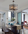 Antique Black Hanging Pendant Light With Crystal Drum Shade installed above dining table, modern vintage glow.