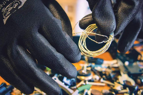 Close-up of hands wearing PUG17 Lightweight Polyurethane Dipped Work Gloves handling wires, showing anti-static grip.