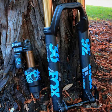 Heritage Decal Kit For Fox Forks And Shocks Dope Look Colorful Durable Sticker Set on black forks and shocks, leaned on tree.