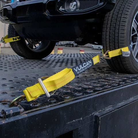 Complete Axle Strap Tie Down Kit With Snap Hook Ratchet Straps In Classic Yellow securing vehicle on flatbed