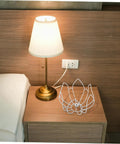 DIY Flower Wire Light Cage Frame For Pendant Lamps Built From Heavy Duty Iron on a nightstand beside a lamp.