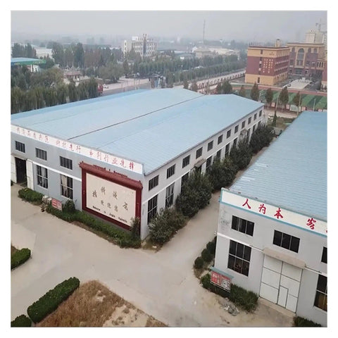 Aerial view of a factory facility featuring multiple buildings with blue roofs and greenery, representing industrial work environment.