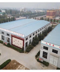 Aerial view of a manufacturing facility featuring large buildings with blue roofs and signage for Tough As Nails Hydraulic Torque Wrench.
