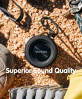 Compact Waterproof Portable Bluetooth Speaker with deep bass on gravel, featuring dual pairing and 24 hour playtime.
