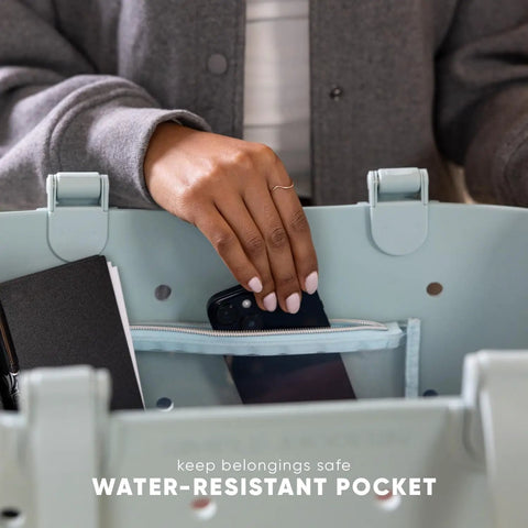 Hand placing phone in Extra Large Beach Tote Bag Waterproof EVA Tote with Zipper Pocket, showcasing water-resistant feature.