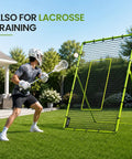 Volleyball Rebounder Net 7x4 Ft With Five Adjustable Angles in backyard used for lacrosse training, person practicing with stick.