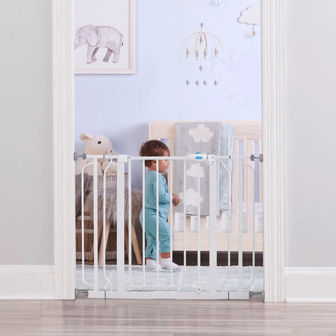 Child standing by extra wide baby safety gate for openings from 29 to 41.5 inches, 30 inches tall, with two 4 inch extensions, in nursery.