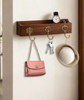 Wooden shelf with Ten Pack Vintage Metal Wall Hooks Set With Bronze Finish holding bag, keys, and hat