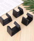 4 Pack Black Plastic Sofa Clips For Sectional Couches And Furniture Connectors on wooden surface with leaf and paper