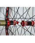 700C Road Bike Wheelset With Carbon Hub And 30mm Aluminum Double Wall Rim Quick Release Front And Rear Caliper And V Brake Compatible Seven to Eleven Speed Cassette Ready Matte Black close-up of carbon hub and spokes in red accents.