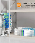 Stacked blue and green oversized folding aluminum beach chairs with webbed seat and detachable cup holder under shelves.