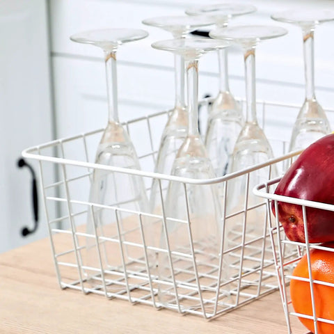 Set Of 4 White Wire Storage Baskets For Freezer, Pantry, And Bathroom Organization with glassware and fruits on a counter