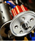 Close-up of a Gen7 Upgrades 45 Hardened Steel Beefy Spur Gear 87T installed on RC car motor, showing silver finish and gear teeth.