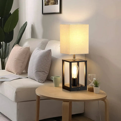 Two Bulb Farmhouse Bedside Lamp With USB Ports And AC Outlet Cozy Beige Fabric Shade Table Light For Bedroom Living Room Bulbs Included Ideal For Reading And Relaxing on side table next to a sofa