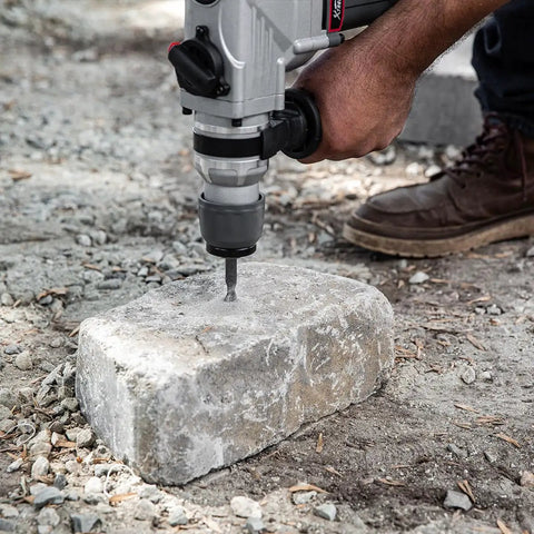 Using Electric SDS-Plus Rotary Demolition Hammer 1180W With 1-1/4 Inch Bit Capacity on a concrete block outdoors