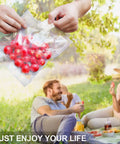 Hands holding Meal Prep Ready Vacuum Sealer Bags For Food Storage 6x8 Inch 15x20 Cm Precut with cherries in picnic setting
