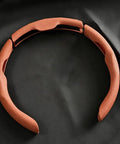Top Shelf Nappa Leather Steering Wheel Cover With Perforated Breathable Weave To Beat The Summer Swelter And Give Your Grabs A Sweet Confident Grip For Your Daily Rig Matching Cybertruck Models Twenty Four Through Twenty Six. Close-up of the orange perforated leather steering wheel cover with snap locks.