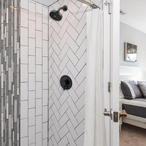 Shower and tub trim kit in matte black; Moen Posi-Temp-compatible valve trim with wall-mount shower head installed