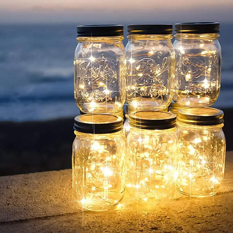 Battery Operated Fairy String Lights 10 Ft Copper Wire With 30 Micro LEDs in mason jars, glowing warmly at dusk on a ledge.
