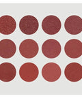 Assorted 12 round red eyeshadow pans with various finishes on a gray background, suitable for makeup application.