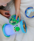Child playing with Durable Light And Sound Camping Lantern Toy With Six Color Modes and scene cards on a bed.