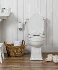 Zero Fuss Potty Training Toilet Seat For The Whole Fam With Built In Magnetic Toddler Cup And Slow Close Lid Steady Hold Elongated Style Crisp White Bathroom Essential displayed in a modern bathroom.