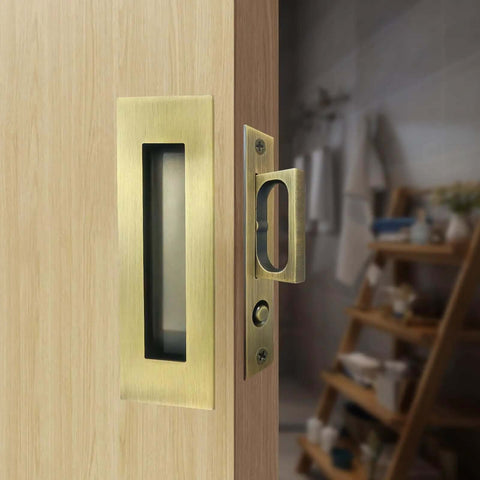 Recessed Finger Flush Pulls With Edge Pull Antique Brass 6 Inch Pop Up Pull installed on a wooden pocket door