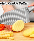 NOVANO stainless steel crinkle cutter, side view with ridged blade slicing a potato on a cutting board