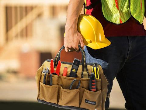 Construction worker holding Wide Mouth 14 Inch Tool Bag Gear Bag For Plumbers Electricians And DIY Handymen With Heavy Duty 900D Polyester Build Also Great For Daily Office Use Travel Camping And Fishing Tan, filled with tools, wearing safety gear.