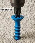 Close-up of blue 100 Pack Three Sixteenth Inch By One And Three Quarter Inch Flat Head Phillips Diamond Tip Concrete Screw in stucco.