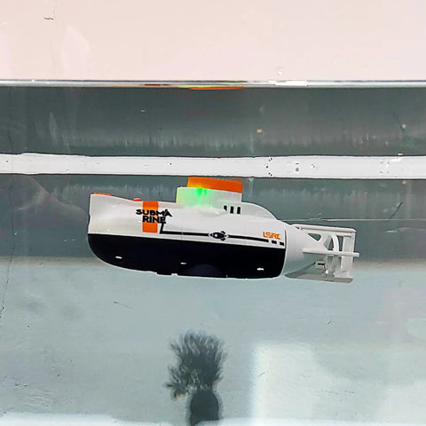 Super Cool RC Submarine Toy For Surface And Deep Water Diving floating in a glass tank, showing realistic diving action.
