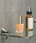 Bathroom scene with items on a glass shelf supported by adjustable glass shelf bracket wall mount made from zinc alloy gold finish shelf supports that grips tight for 3mm to 22mm glass panels ideal for home decor display shelves and storage