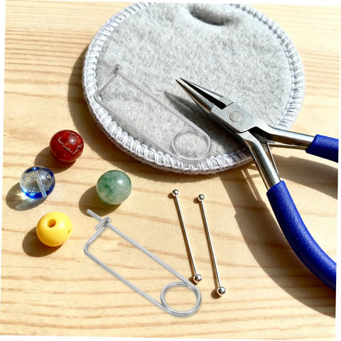 Heavy Duty Stainless Steel Brooch Cotter Safety Spring Pins For Quick Lock with beads and pliers on a wooden surface.