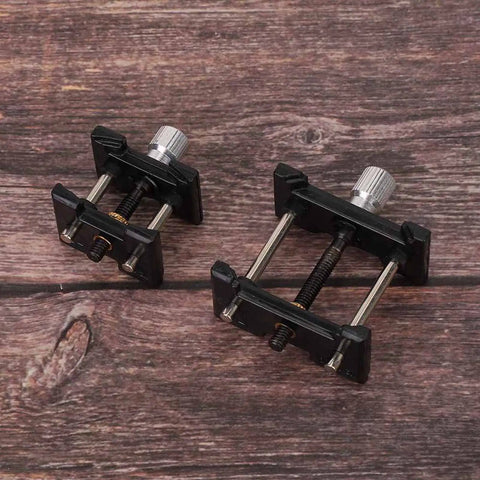 Two Piece Watch Movement Holder Kit With Non Slip Fixed Base and Plastic Repair Tool on wooden surface